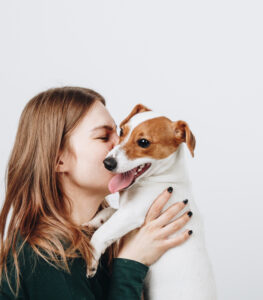 Girl kissing small dog